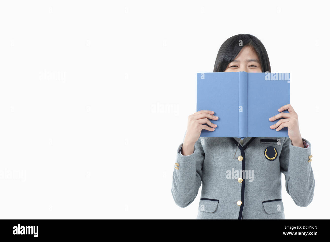 a girl in a school uniform holding a book Stock Photo - Alamy