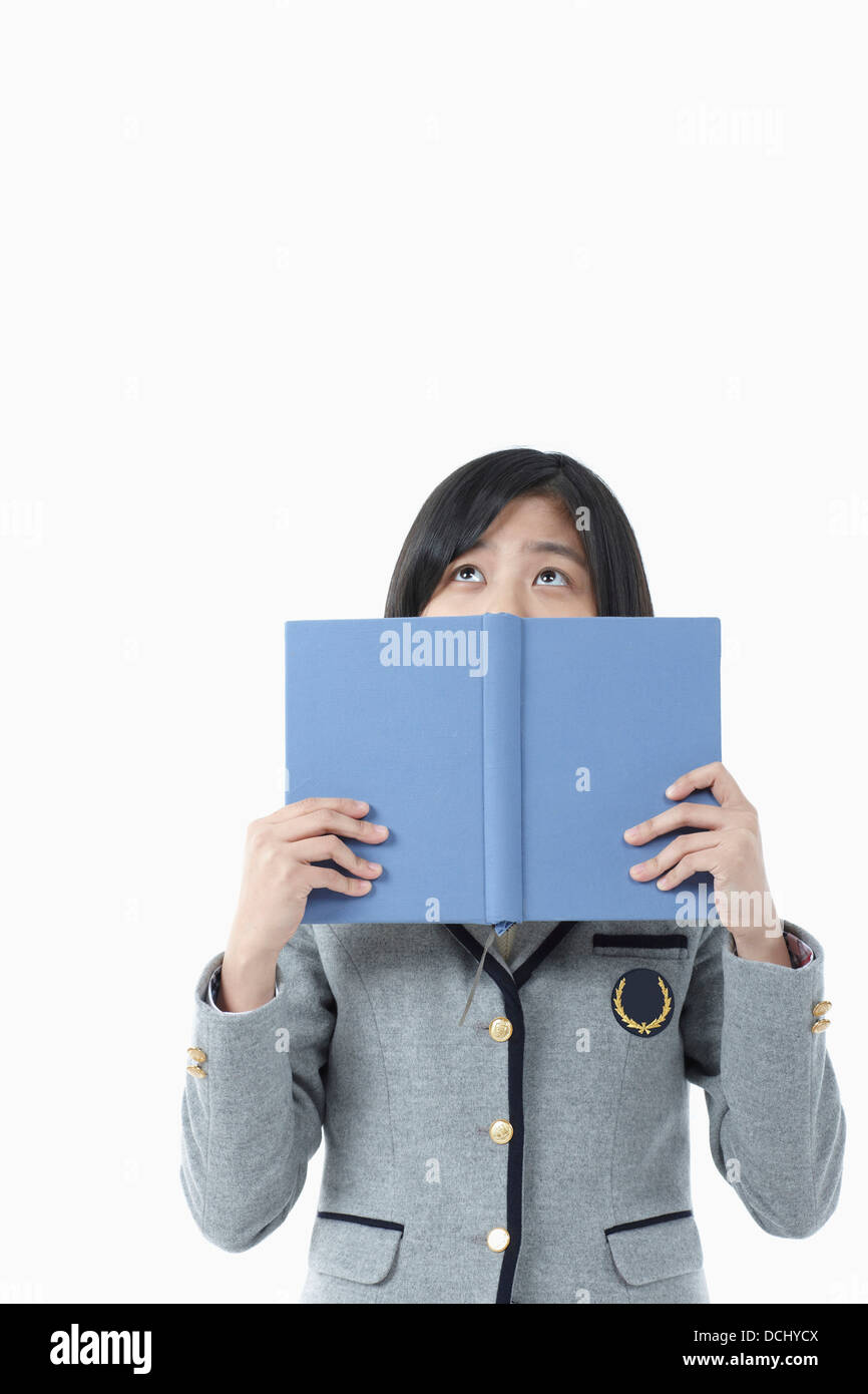 a girl in a school uniform holding a book Stock Photo - Alamy