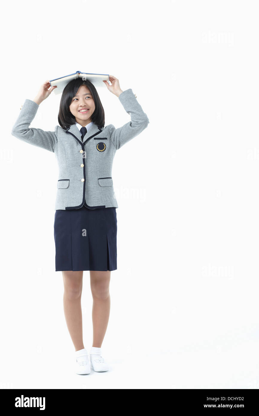 a girl in a school uniform holding a book Stock Photo - Alamy