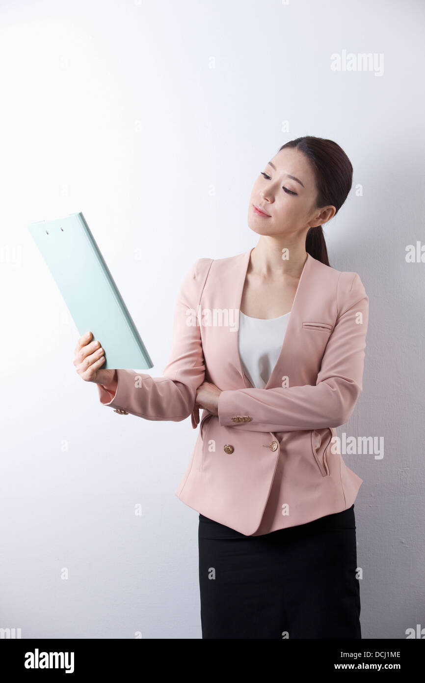 a woman in business suit holding a folder Stock Photo - Alamy