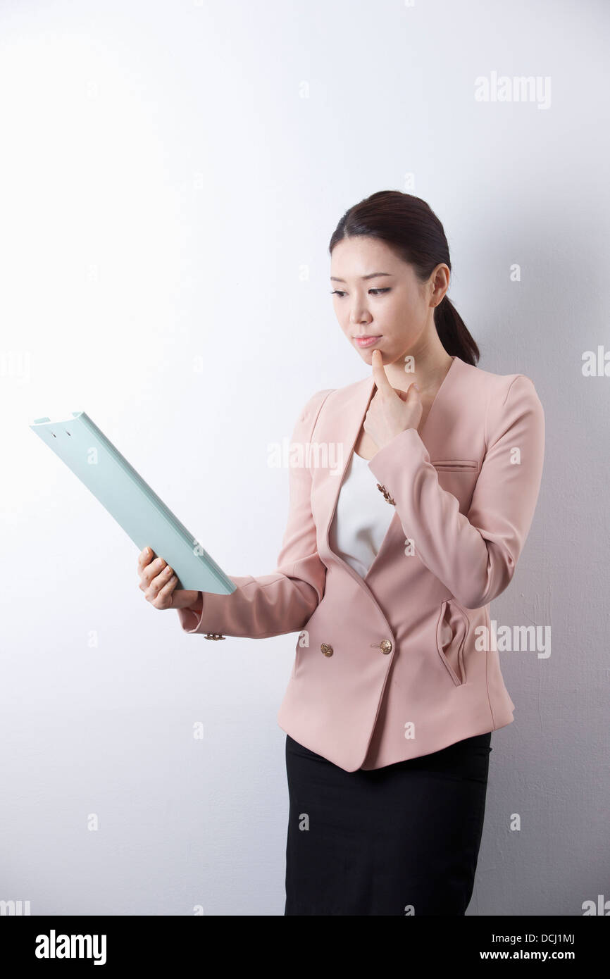a woman in business suit holding a folder Stock Photo - Alamy