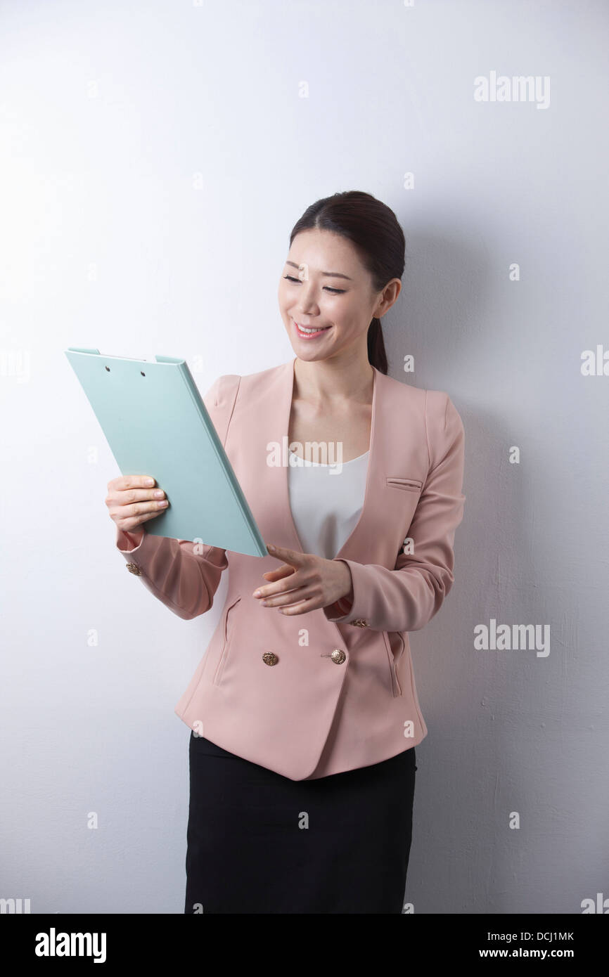 a woman in business suit holding a folder Stock Photo - Alamy