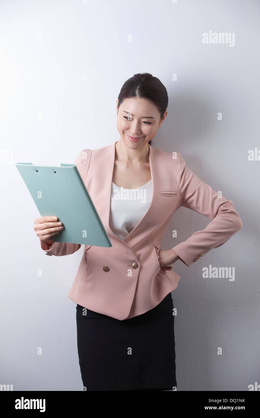 a woman in business suit holding a folder Stock Photo - Alamy
