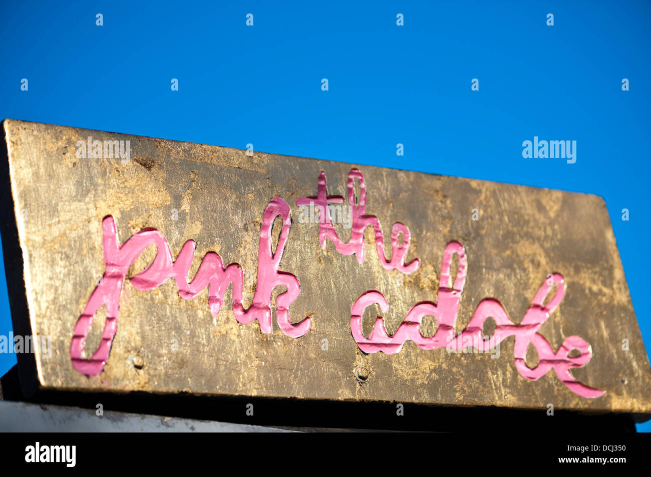 Detail of shop sign the pink adobe written in pink lettering on a gold background against a clear blue sky Santa Fe New Mexico. Stock Photo