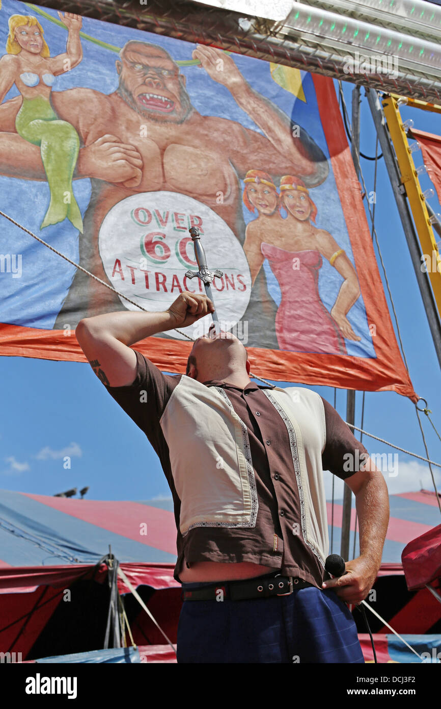 A sword swallower in a carnival act at the Steele County Fair in Minnesota. Stock Photo