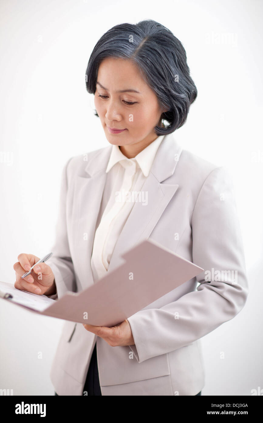 middle aged woman in business suit holding a folder Stock Photo - Alamy