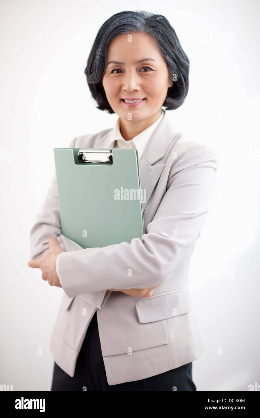 middle aged woman in business suit holding a folder Stock Photo - Alamy