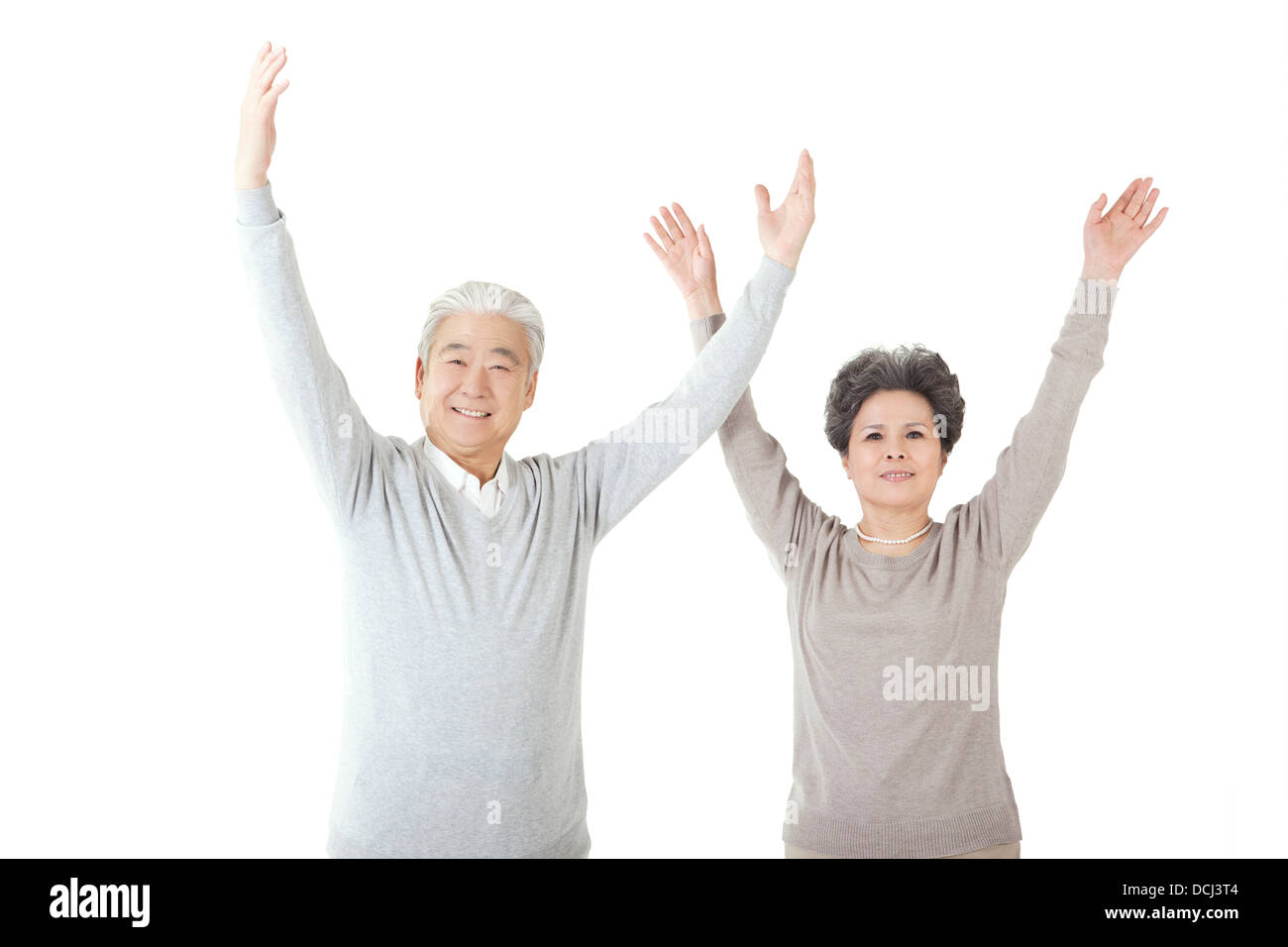 Oriental old couple with arms upraised Stock Photo
