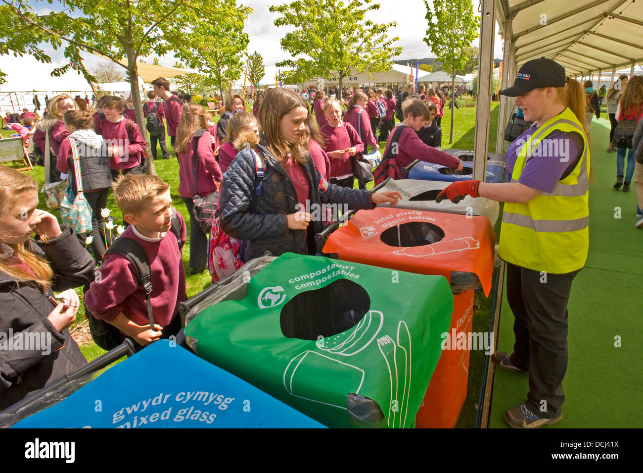 One of the staff at the Hay festival teaching school children the correct bin for recycling Stock Photo