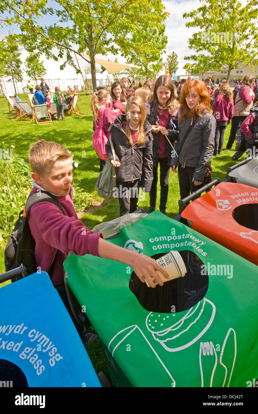 School children at the Hay festival putting waste containers in a bin for recycling. Stock Photo