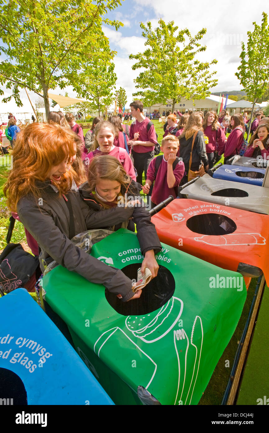 School children at the Hay festival putting waste containers in a bin for recycling. Stock Photo