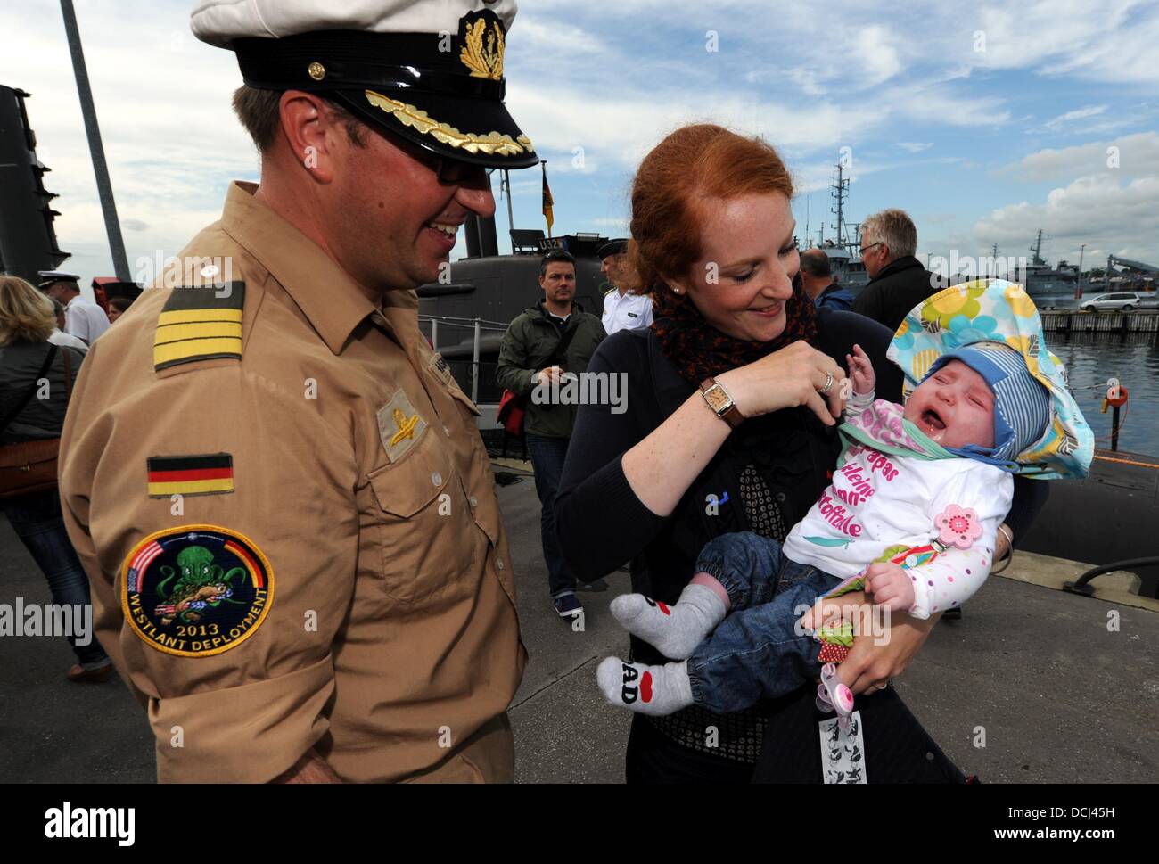 the Baltic Sea Naval Base Eckernfoerde, Germany. 19th Aug, 2013. Commander of the German submarine U32 Christian Michalski is welcomed by girlfriend Vanessa Friese and daughter Charlotte as the submarine has returned to the Baltic Sea Naval Base Eckernfoerde, Germany, 19 August 2013. During the six-month trip the U32 submarine set a diving record by being under water for 18 days. Photo: CARSTEN REHDER/dpa/Alamy Live News Stock Photo