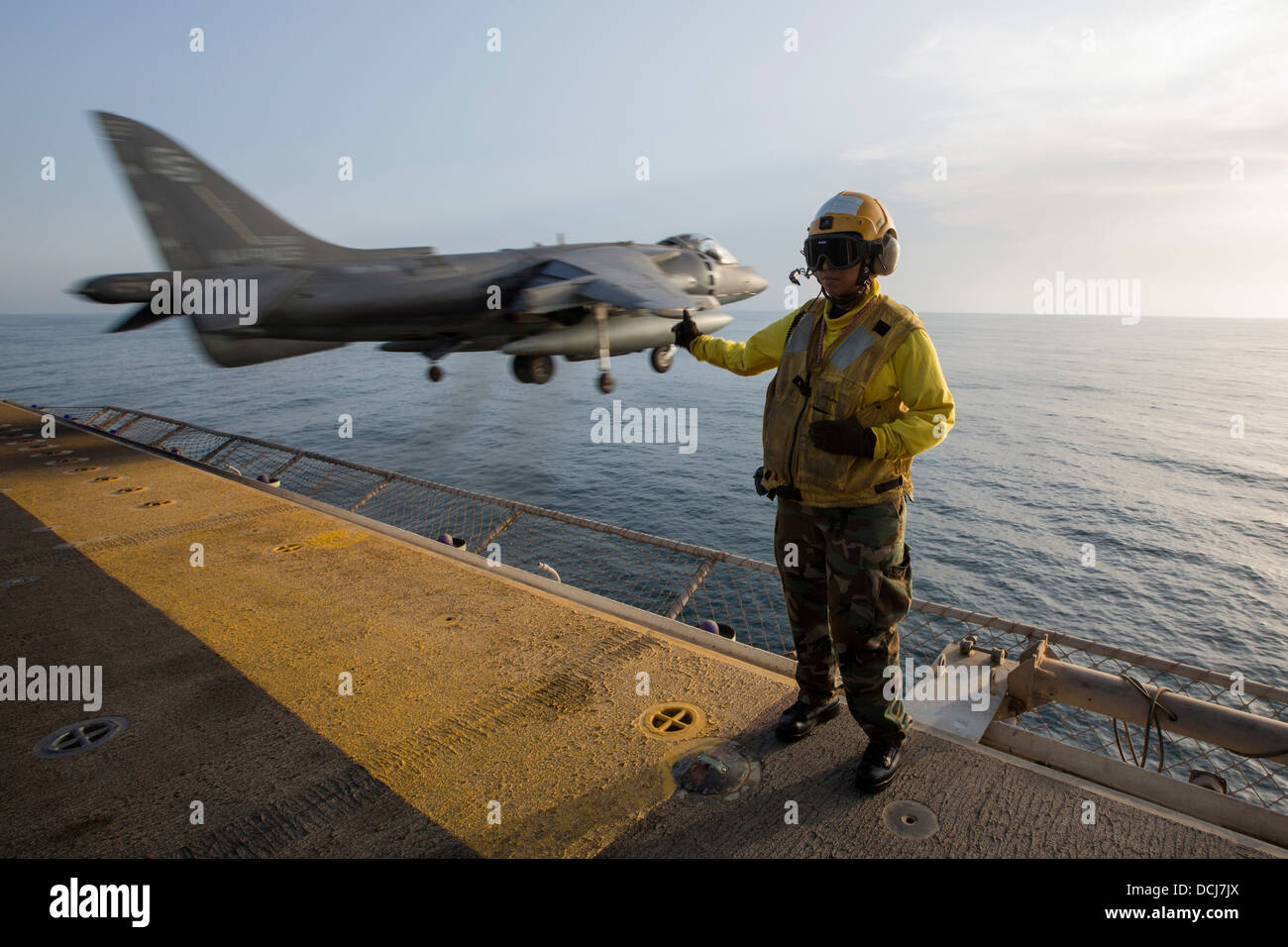 Aviation Boatswain's Mate (Handling) Airman Lucy Pizarro signals as an