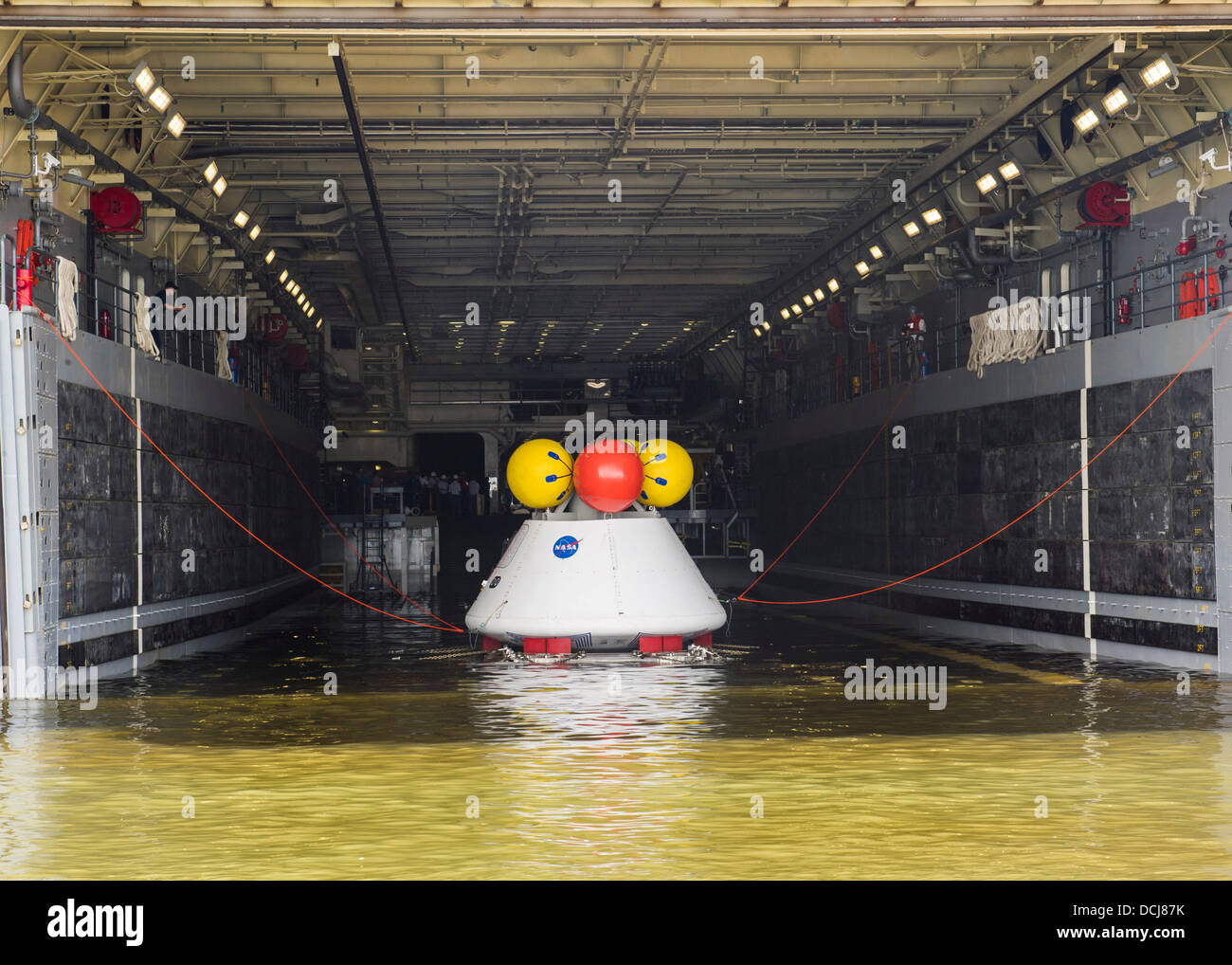 Sailors aboard the amphibious transport dock ship USS Arlington (LPD 24) recover an Orion capsule into the well deck of Arlingt Stock Photo