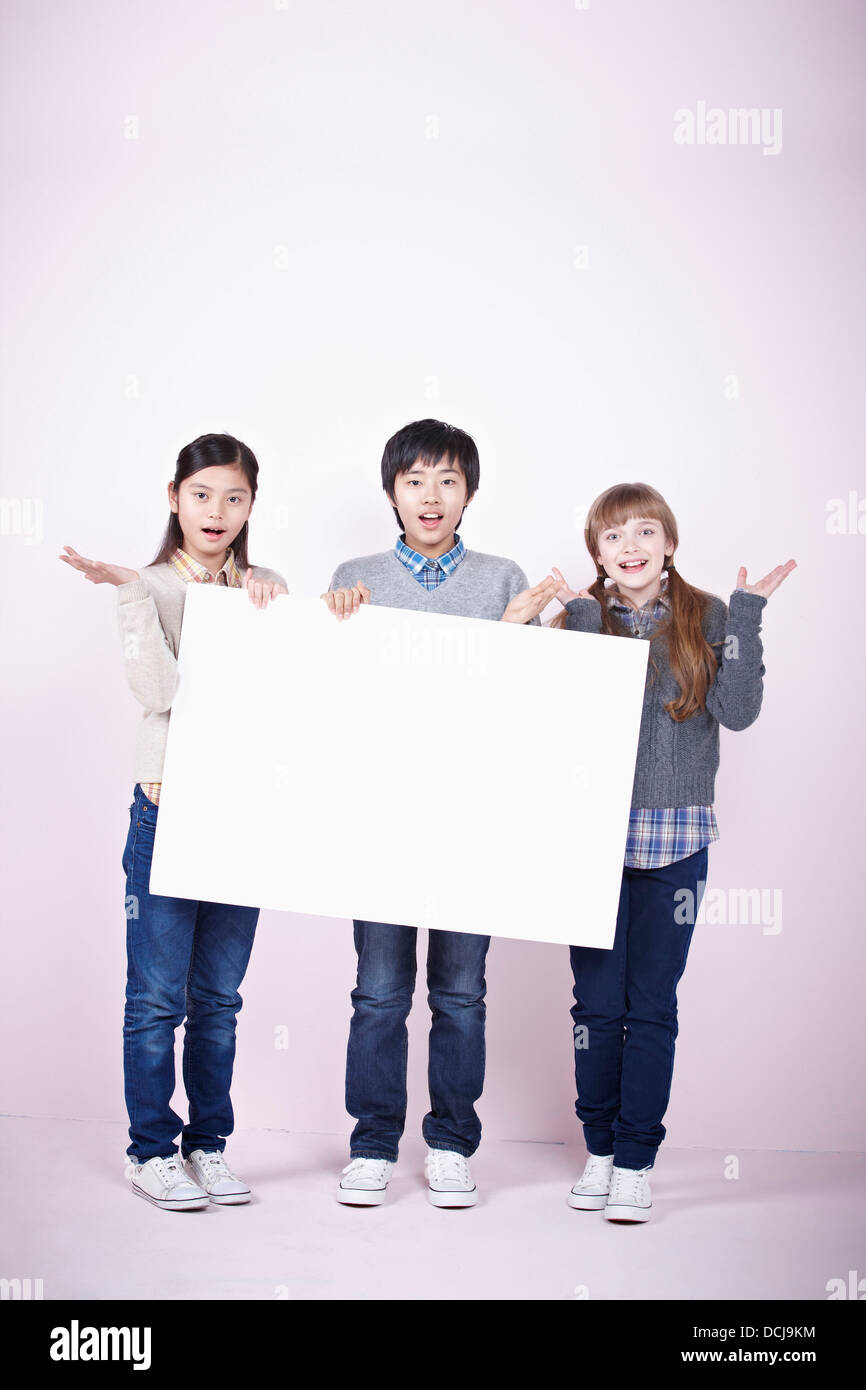 two girls and a boy holding blank board Stock Photo - Alamy