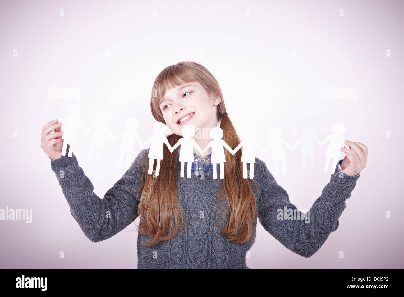 a girl holding continuous paper icons of human Stock Photo