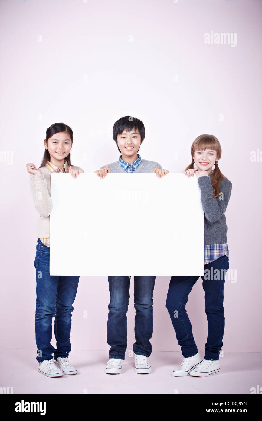 two girls and a boy holding blank board Stock Photo - Alamy