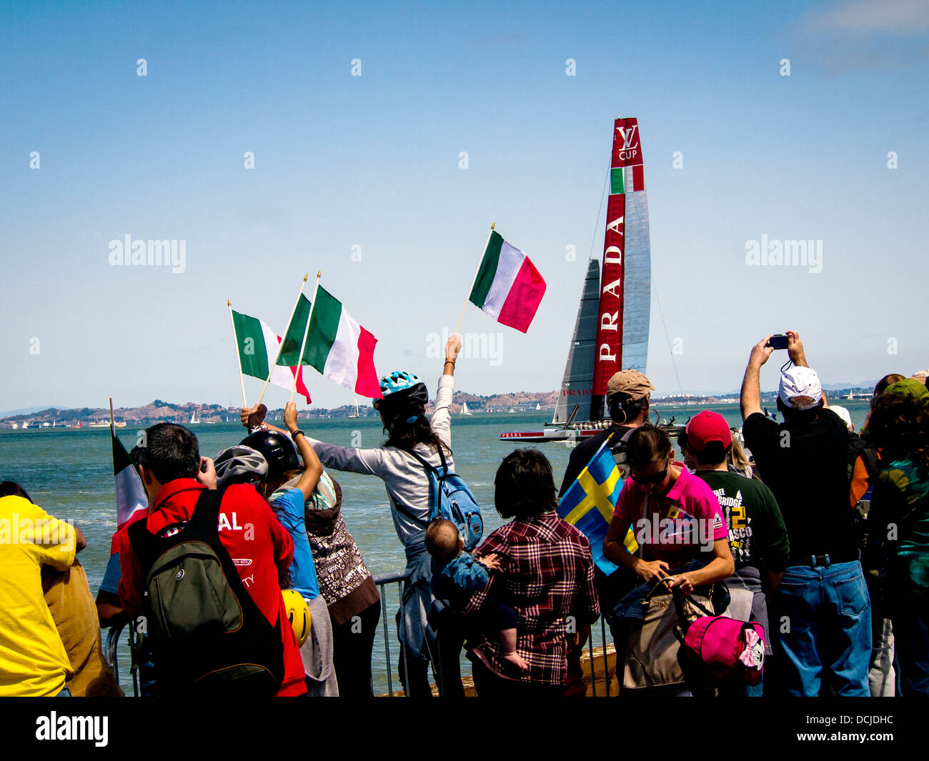 Fans line the shore of the San Francisco Bay cheer on Italy's Luna Rosa in the 2013 America's Cup competition. Stock Photo