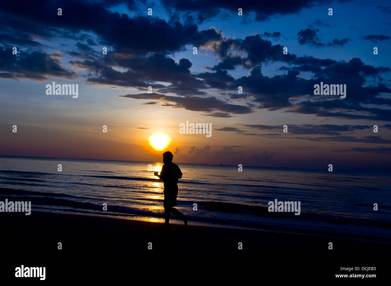 silhouette of man running on the beach Stock Photo