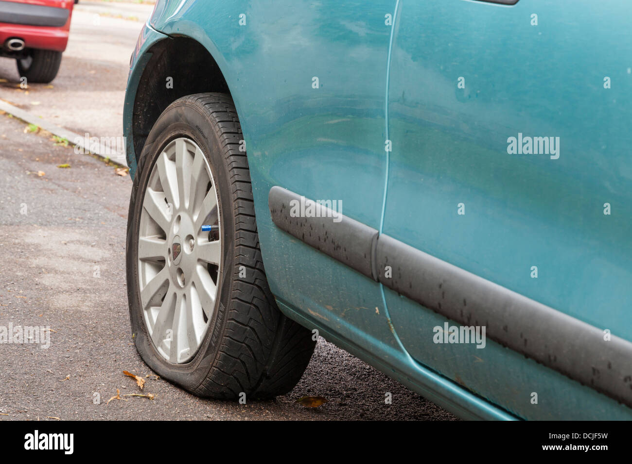 Flat tyre. Car with a punctured tyre parked up at the roadside, England, UK Stock Photo