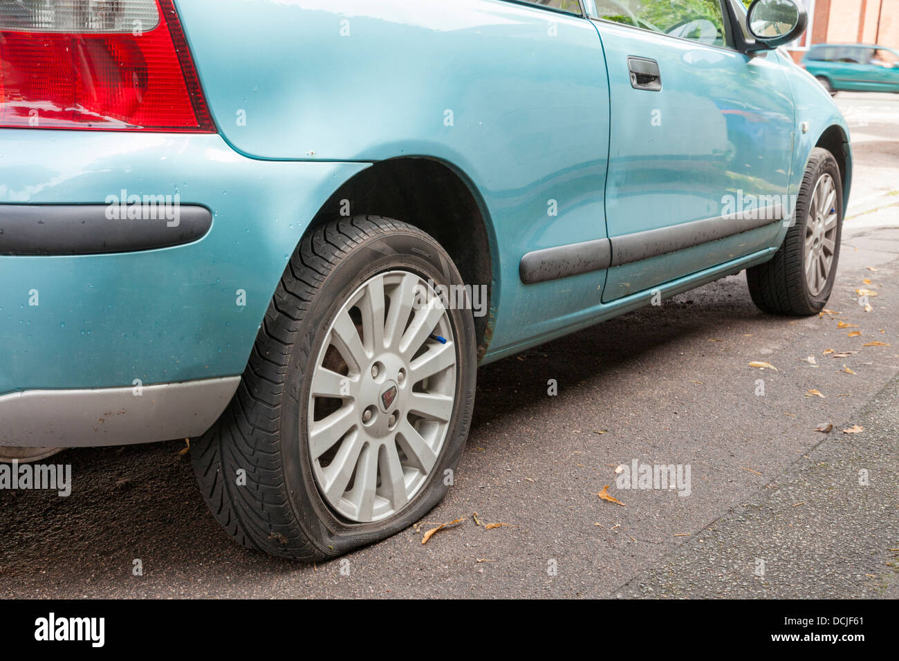 Punctured tyre. Car at the roadside with a flat tyre, England, UK Stock Photo