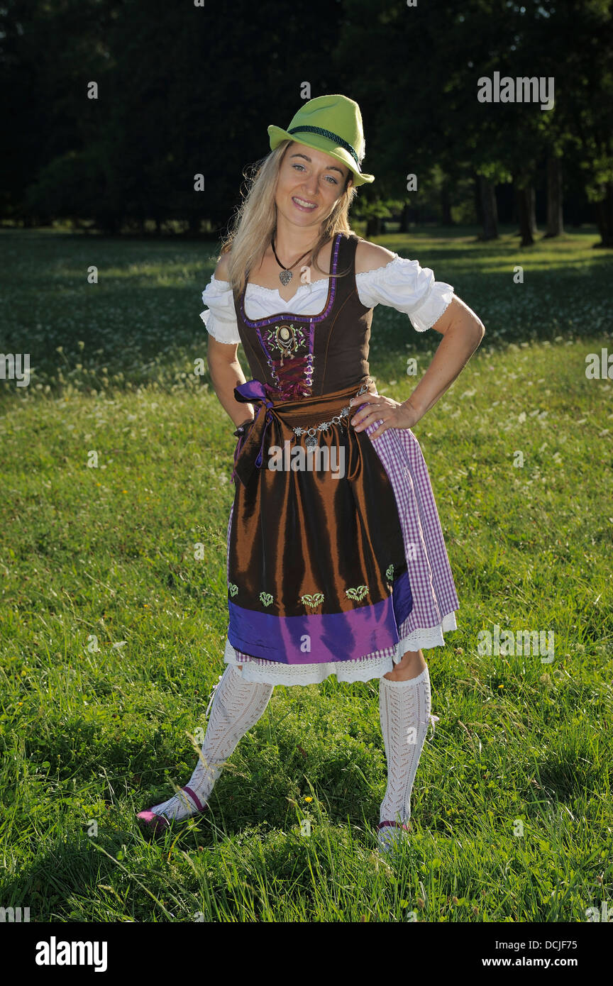 young woman wearing traditional Bavarian dress Dirndl in a park Stock Photo
