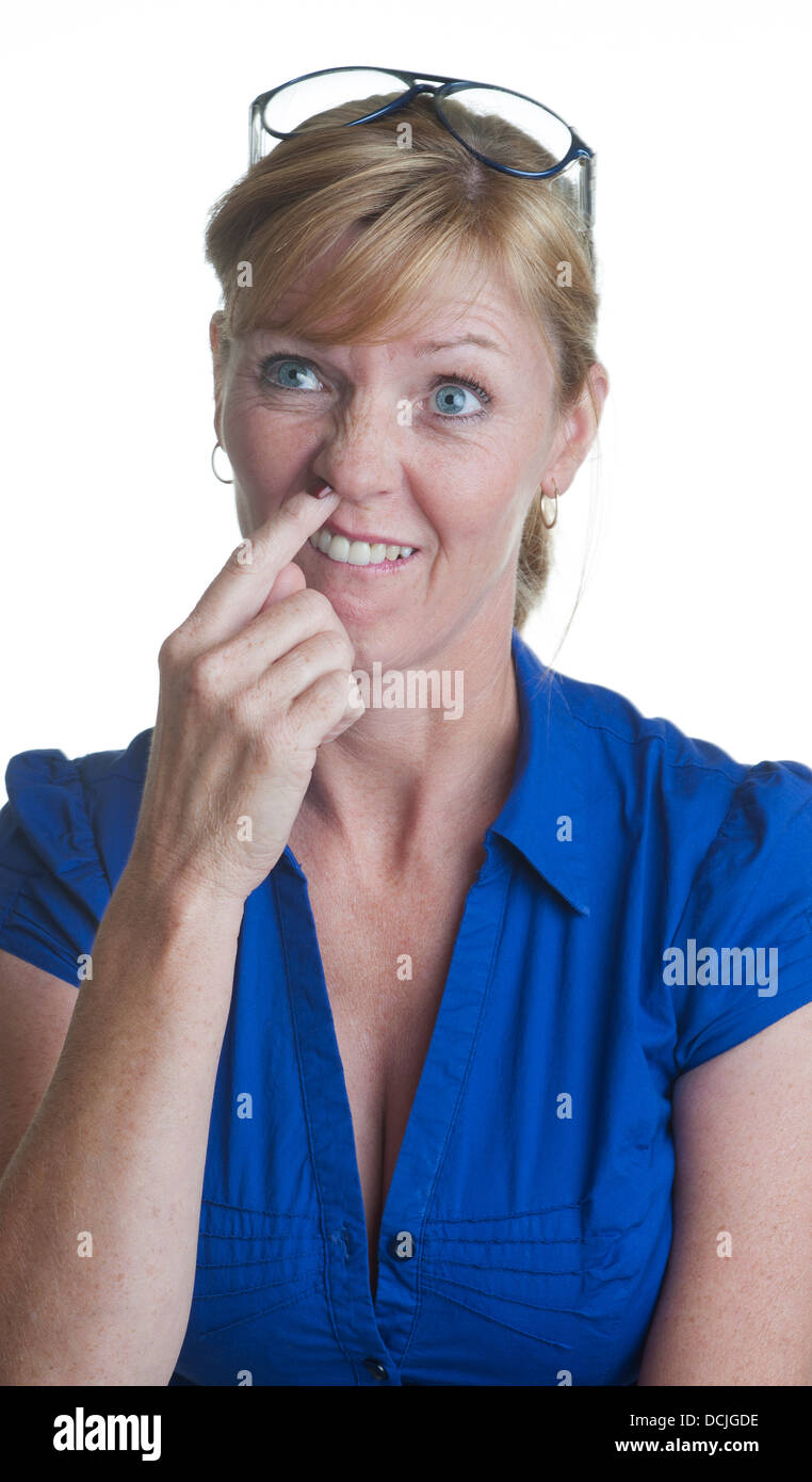 Portrait of a woman in blue shirt with finger up her nose Stock Photo