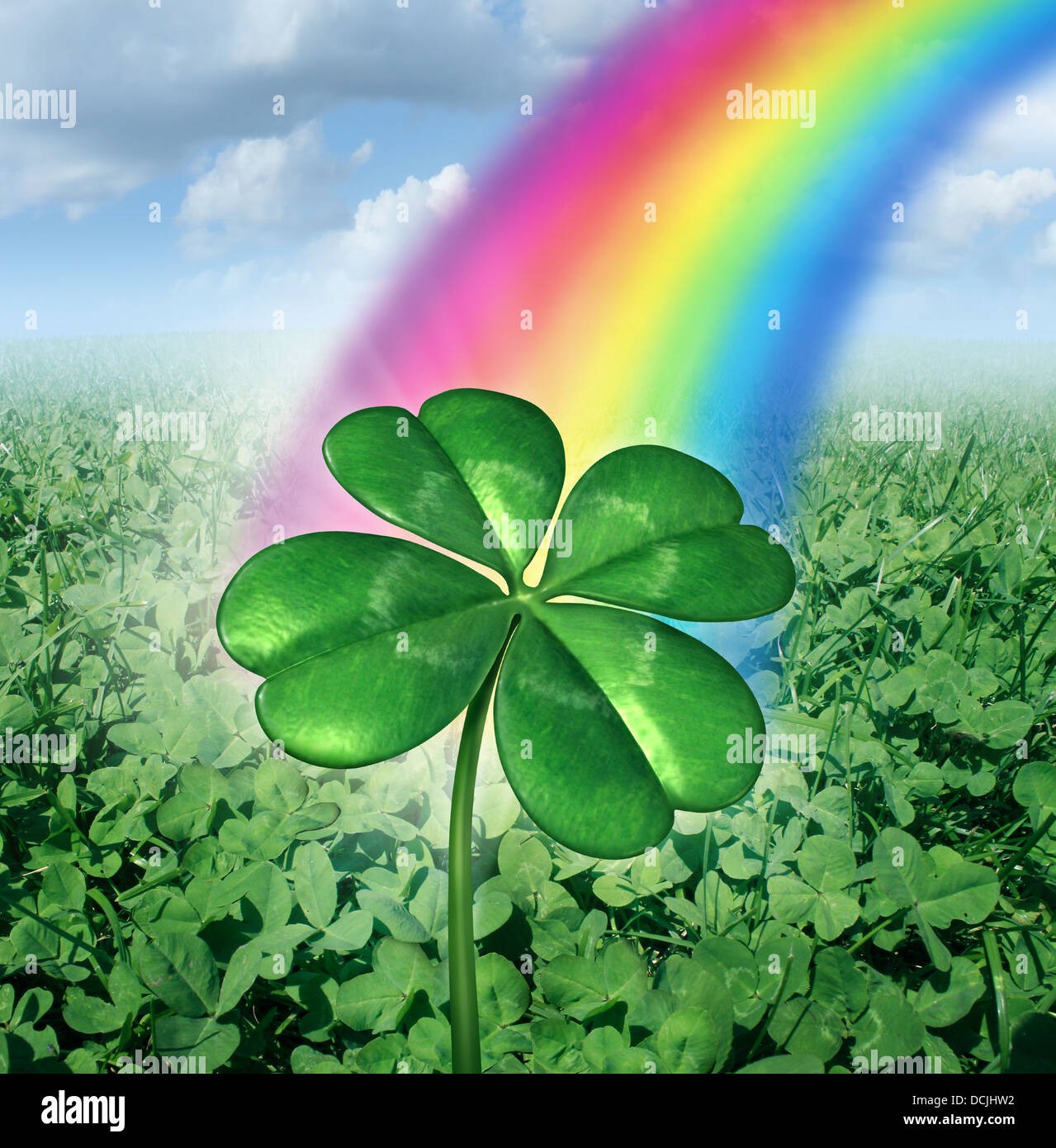 Luck concept with a four leaf clover over a field of green clovers with a rainbow from the sky shinning down as a symbol of good fortune and prosperity as a metaphore for success and opportunity. Stock Photo