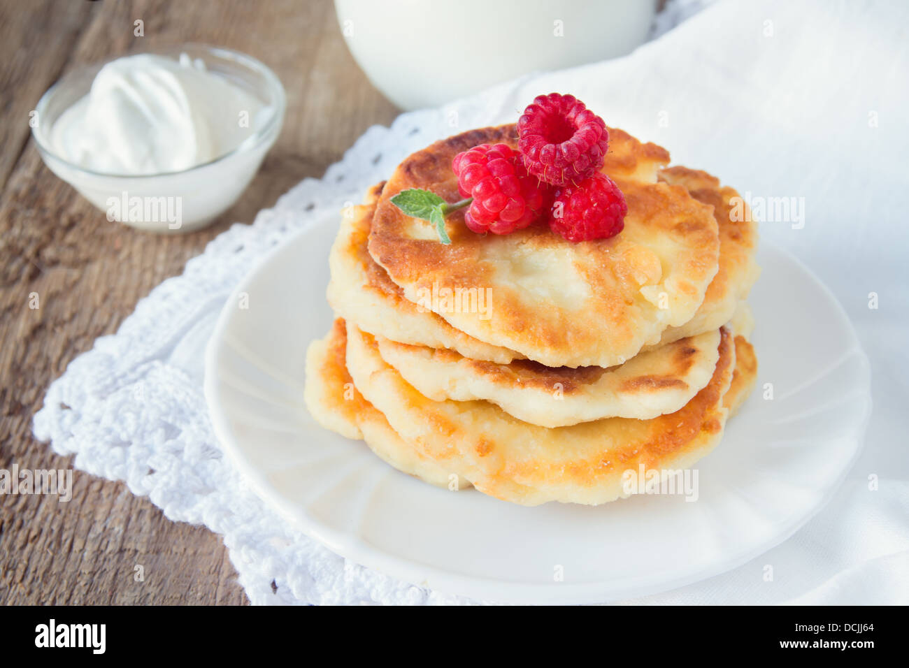 Fritters of cottage cheese with raspberry on wooden table, close up ...