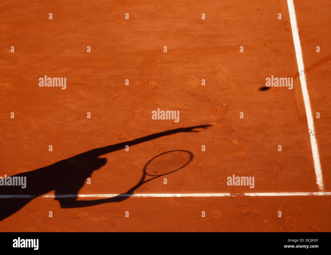 Shadow of a tennis player serving the ball. Stock Photo