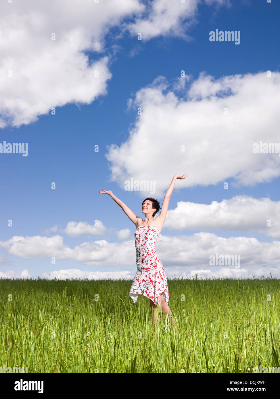Young woman standing on a field Stock Photo - Alamy