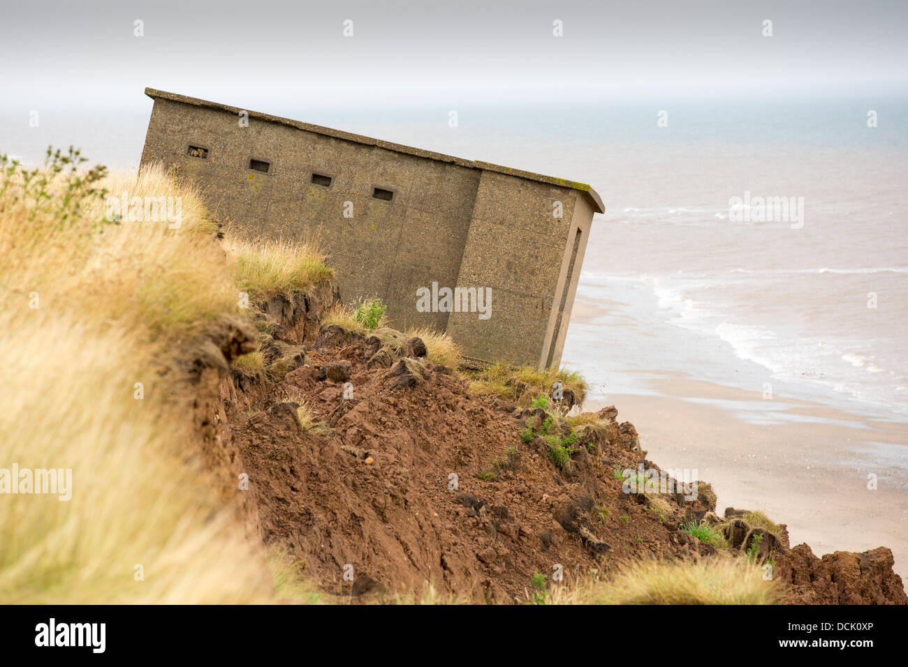 A Second world War lookout post leaning alarmingly and about to tumble over the edge of the cliff near Aldbrough Stock Photo