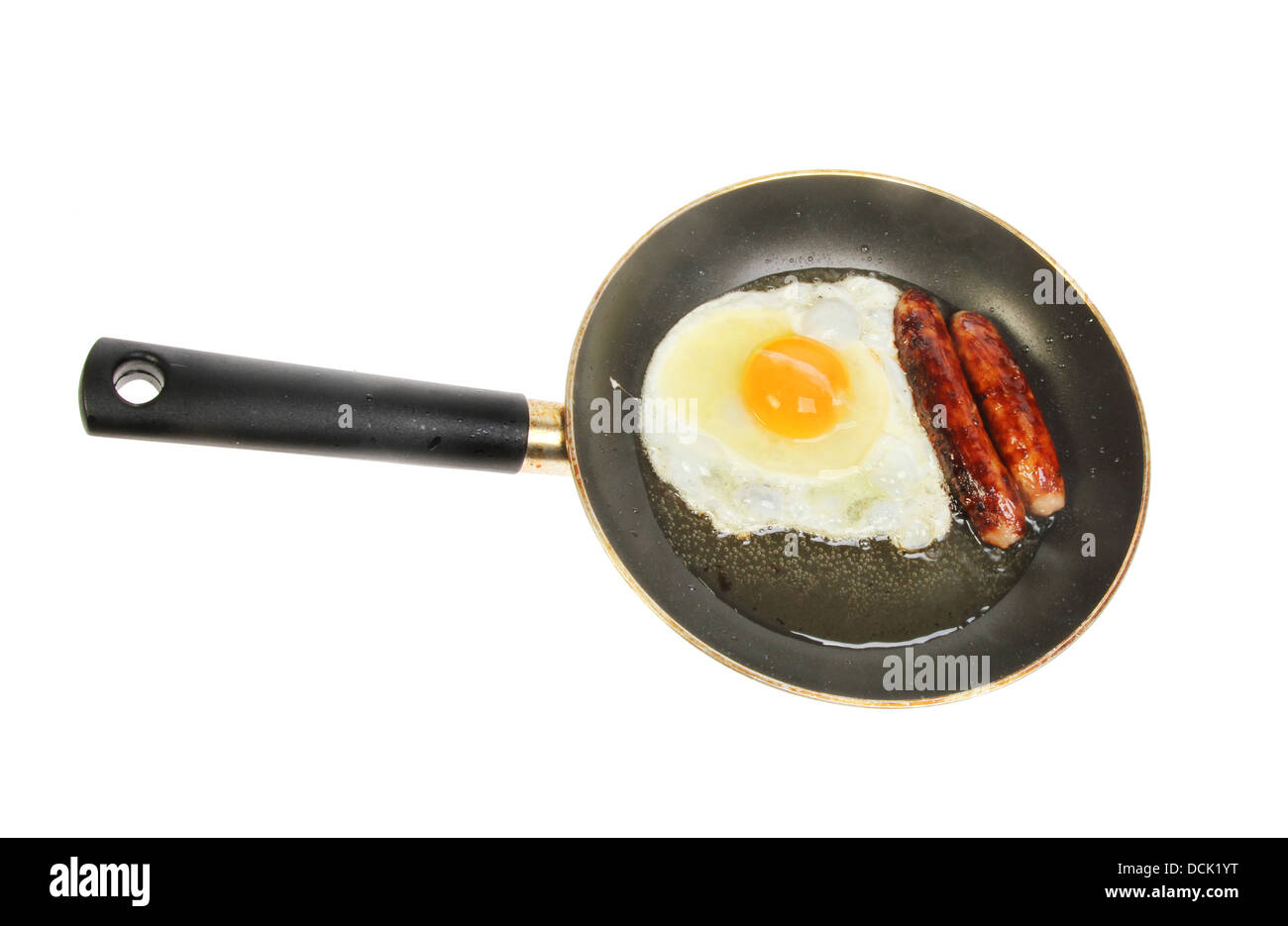 Egg and sausages frying in a pan isolated against white Stock Photo
