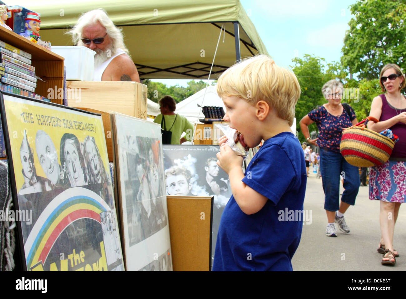 A small child eating ice cream has stopped to look at a vintage Wizard