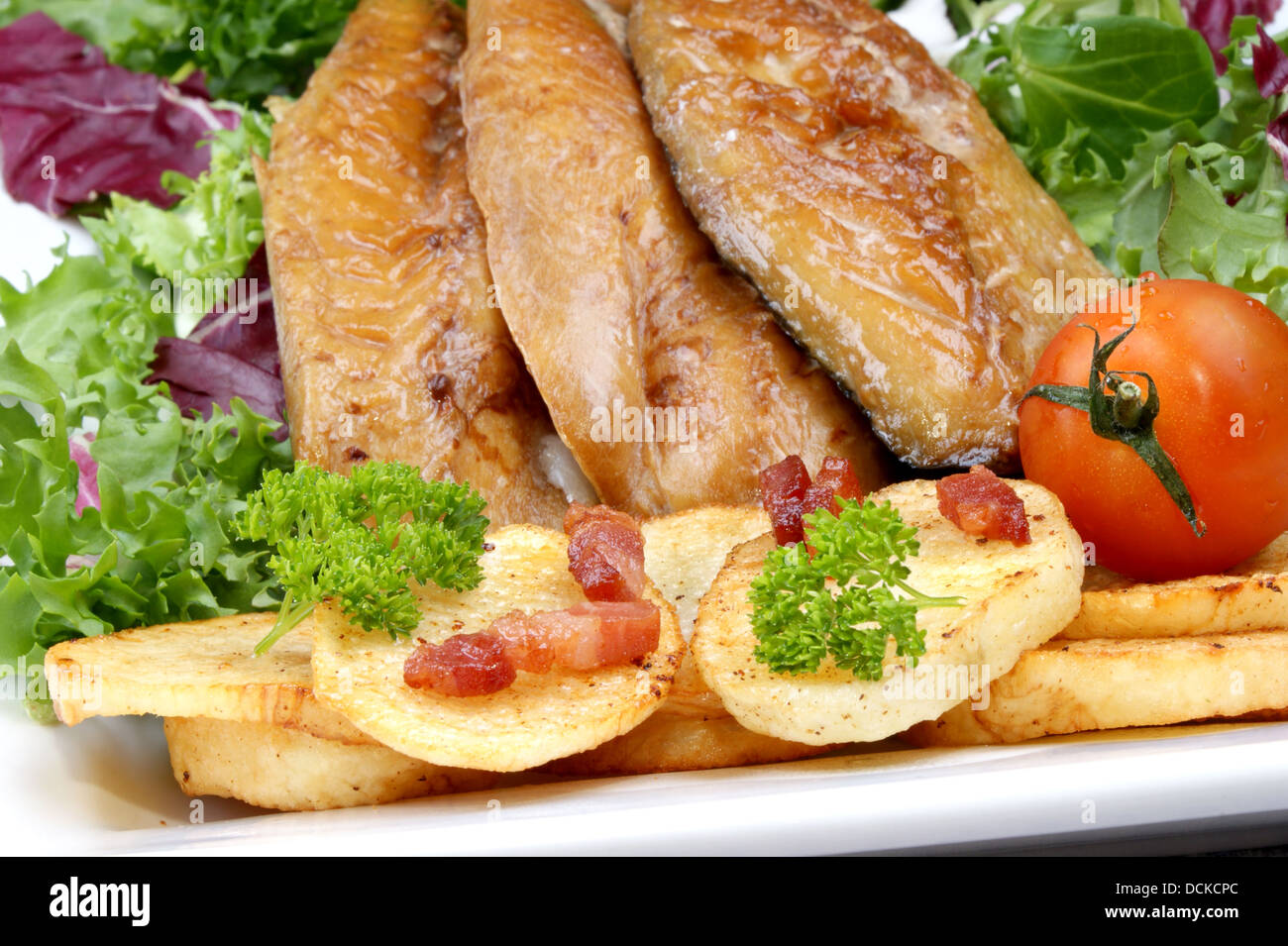 smoked mackerel fillets with fried potatoes and tomato Stock Photo