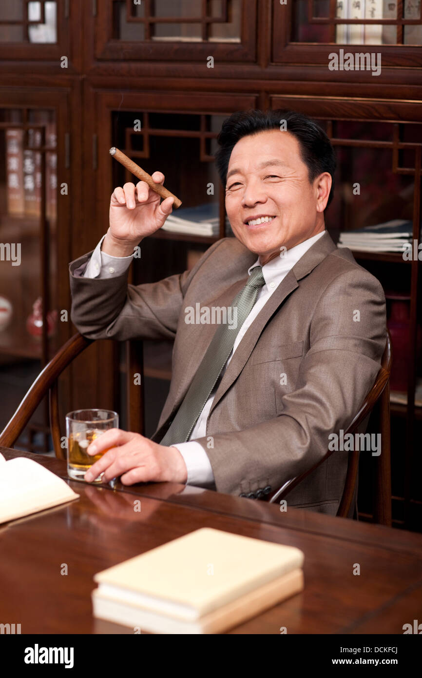 Successful businessman enjoying cigar Stock Photo