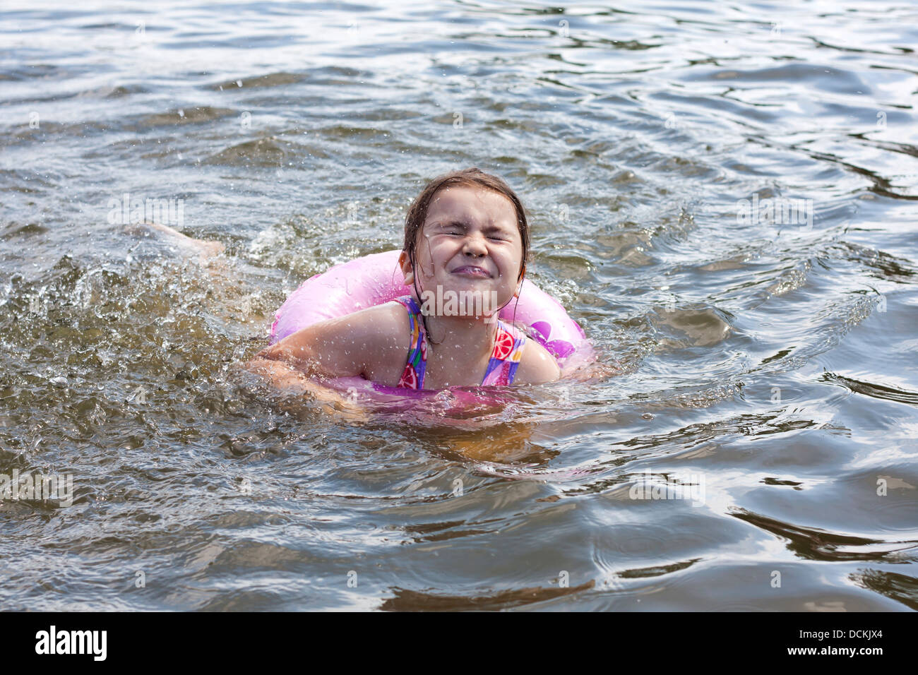 Child learns to swim in the lake with lifebuoy closeup Stock Photo