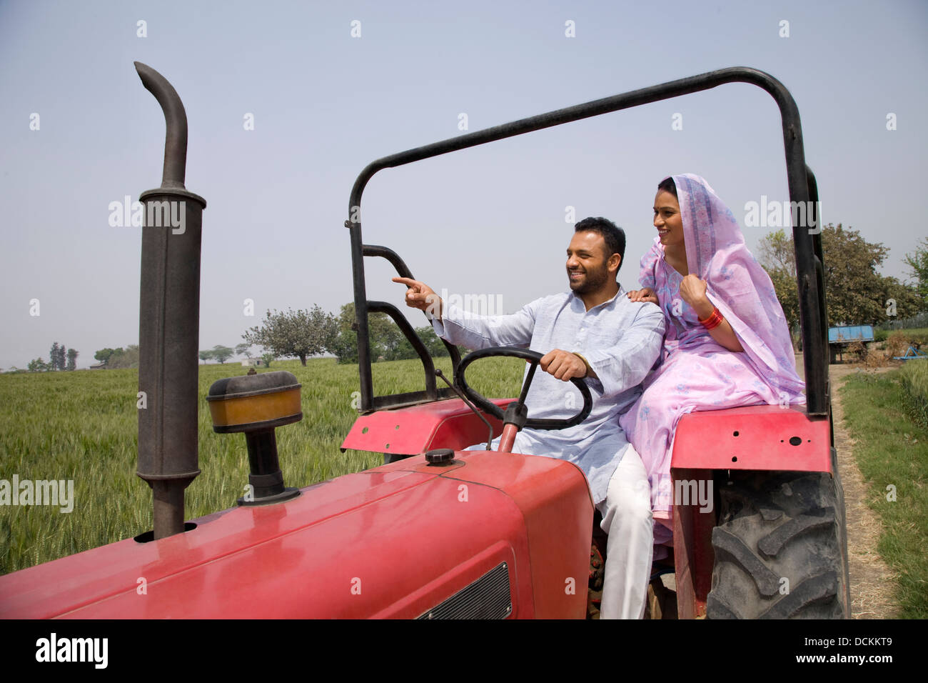 Man showing something to wife while driving a tractor Stock Photo - Alamy