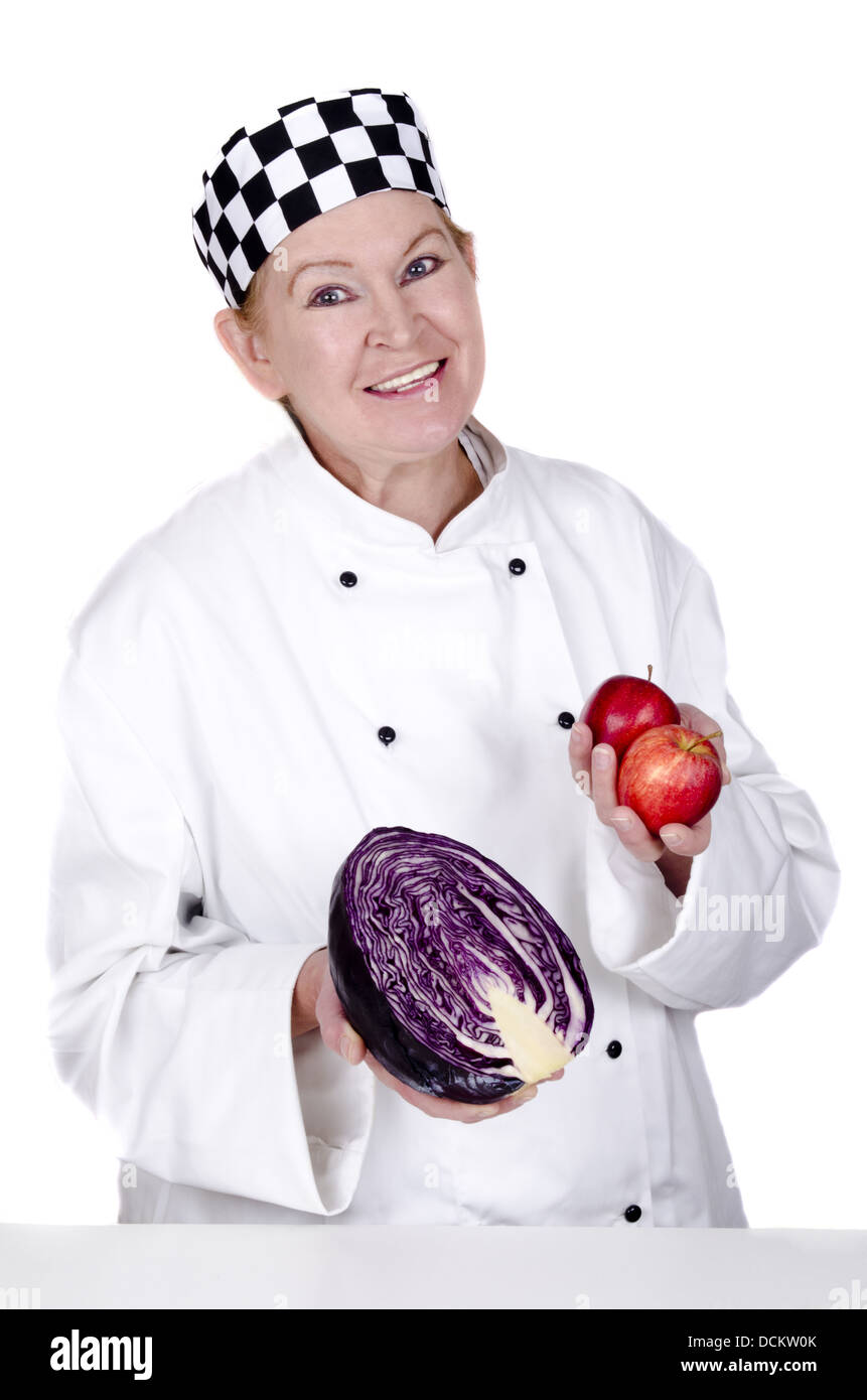 female chef holding a red cabbage and two apples in her hands be Stock Photo