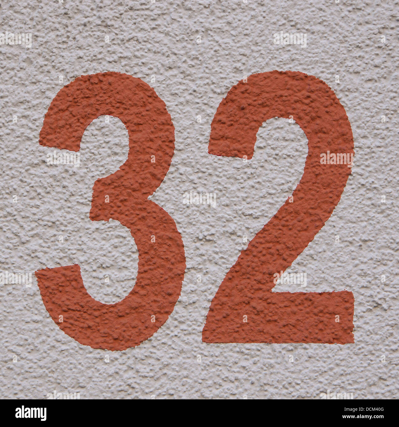 house number thirty two on roughcast background Stock Photo