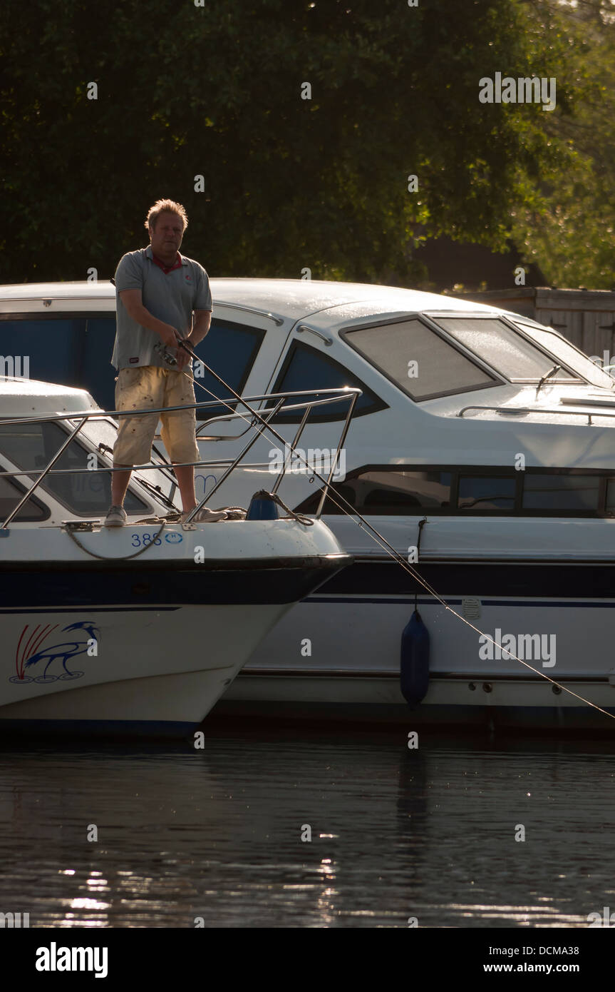 Man fishing from broads cruiser Norfolk Stock Photo