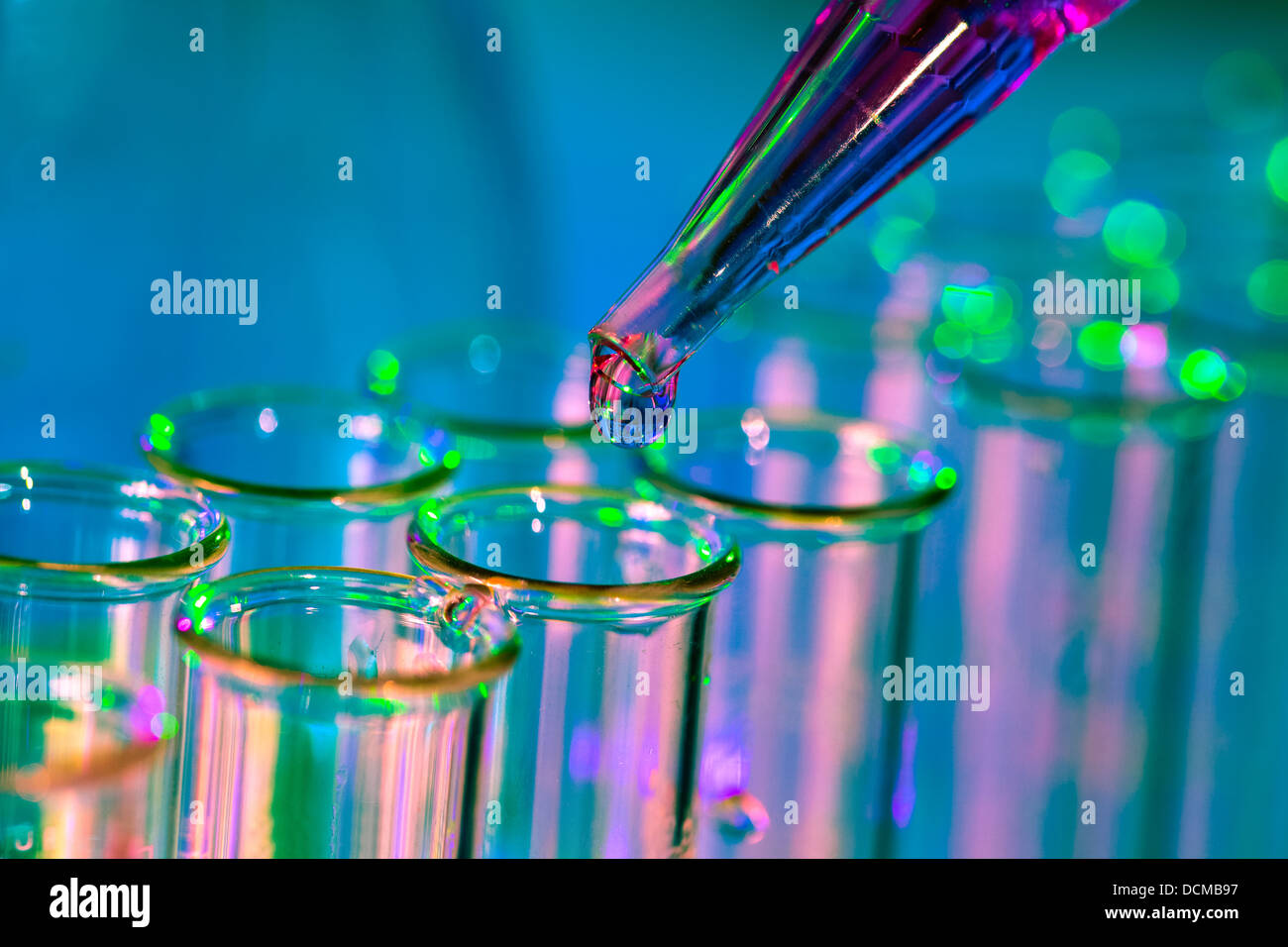 Pipette adding fluid to one of several test tubes Stock Photo