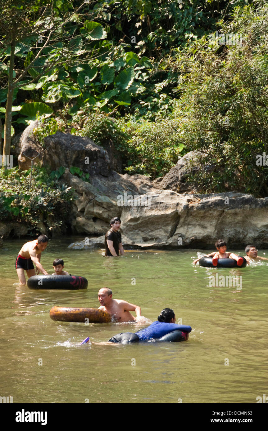 Vertical close up of tourists tubing along Nam Song river near Vang Vieng, post government crackdown. Stock Photo