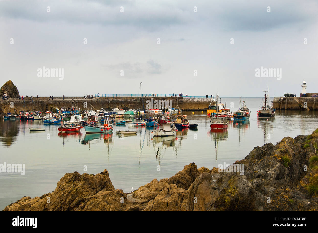 Horizontal panoramic view across the outer harbour at Mevagissey on a dark cloudy day. Stock Photo