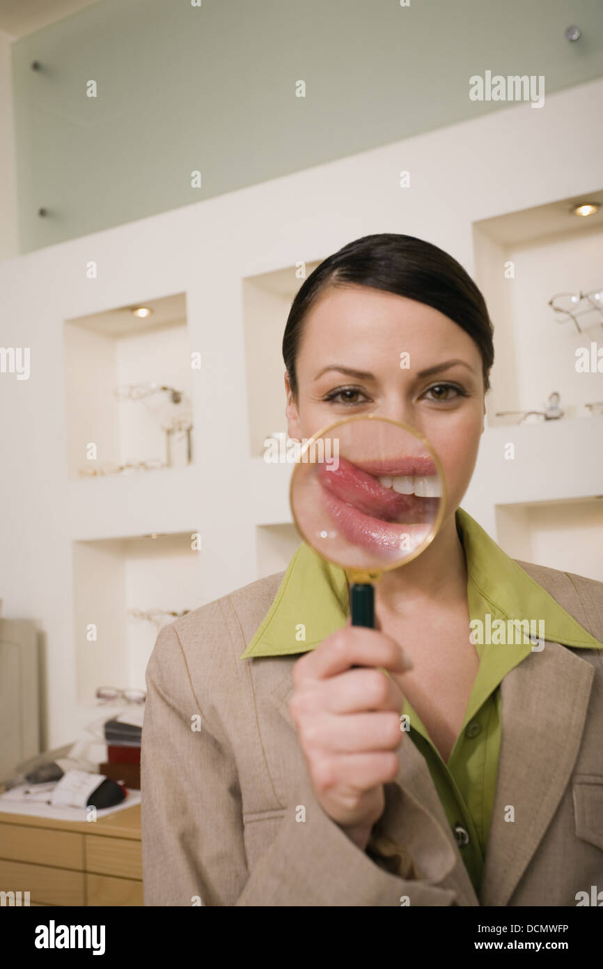 Woman with magnifying glass on mouth with tongue sticking out Stock Photo Alamy