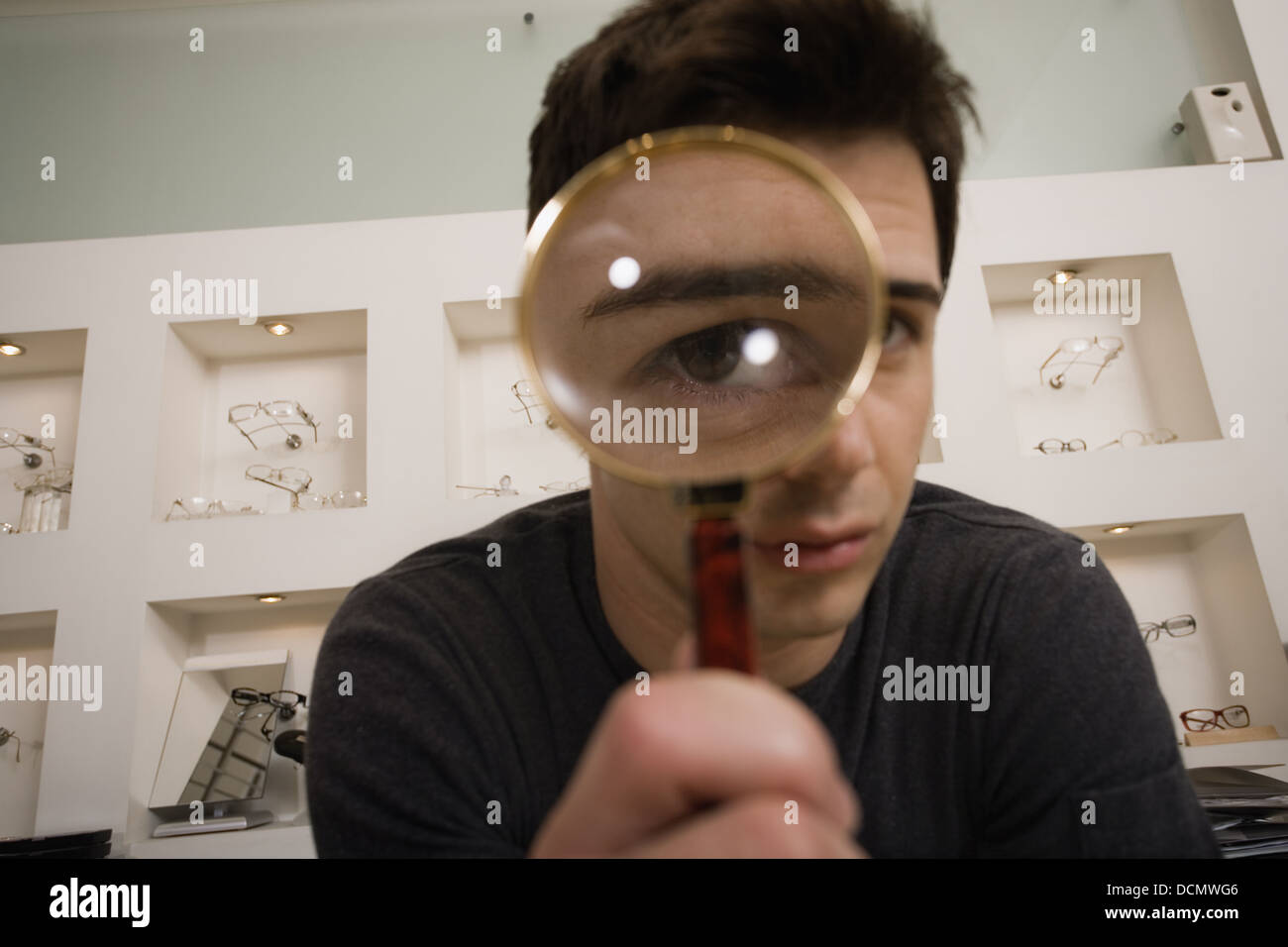 Man with magnifying glass on eye Stock Photo Alamy