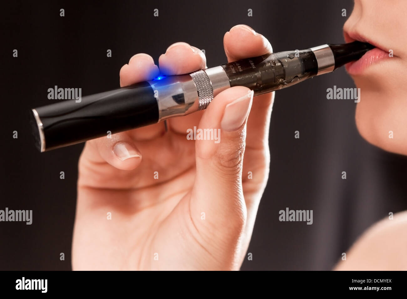 Close up of a woman inhaling from an electronic cigarette Stock Photo