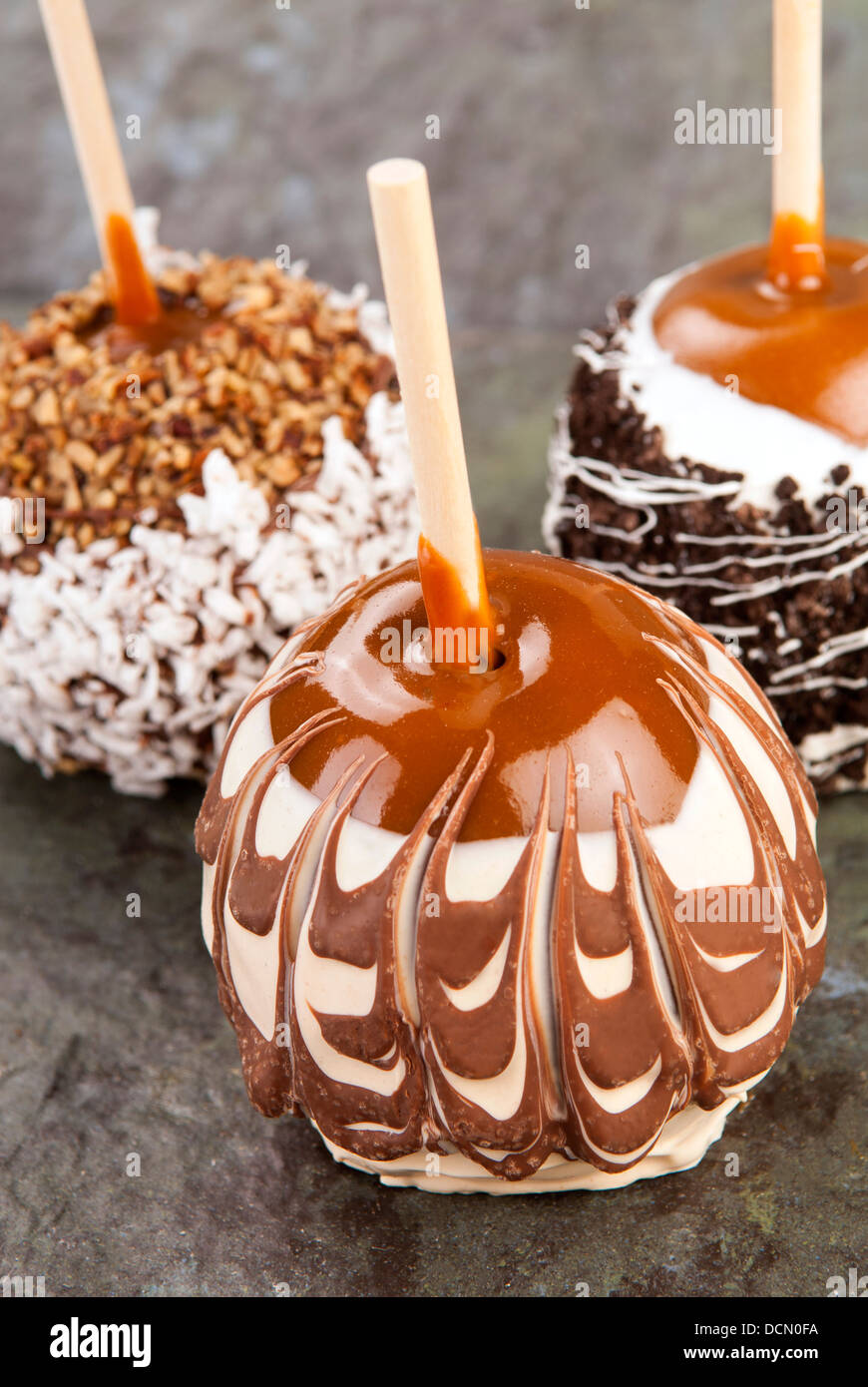 Delicious taffy apples decorated with swirls, nuts and chocolate Stock Photo