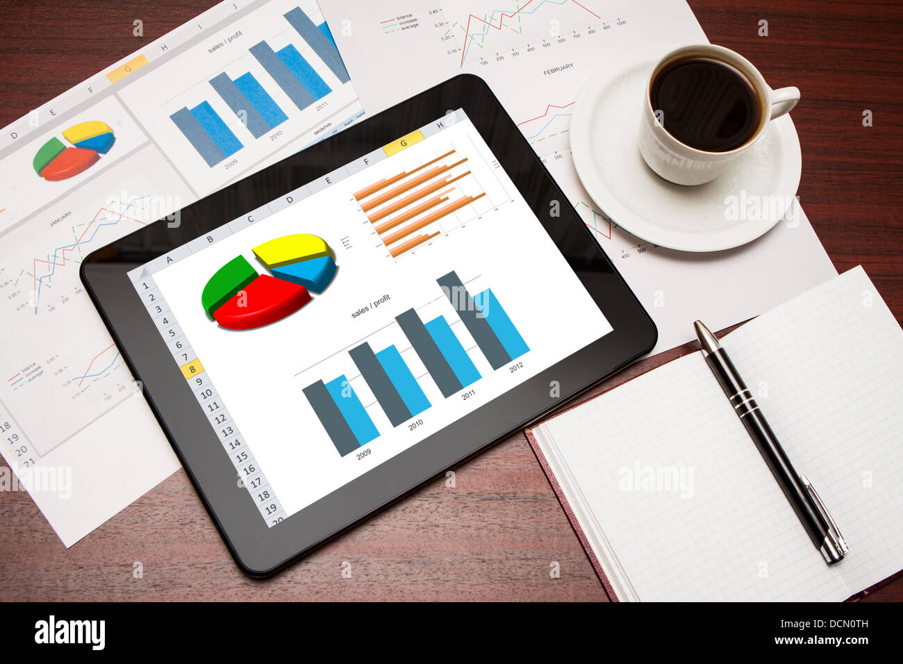 Modern workplace with digital tablet showing charts and diagram on screen Stock Photo