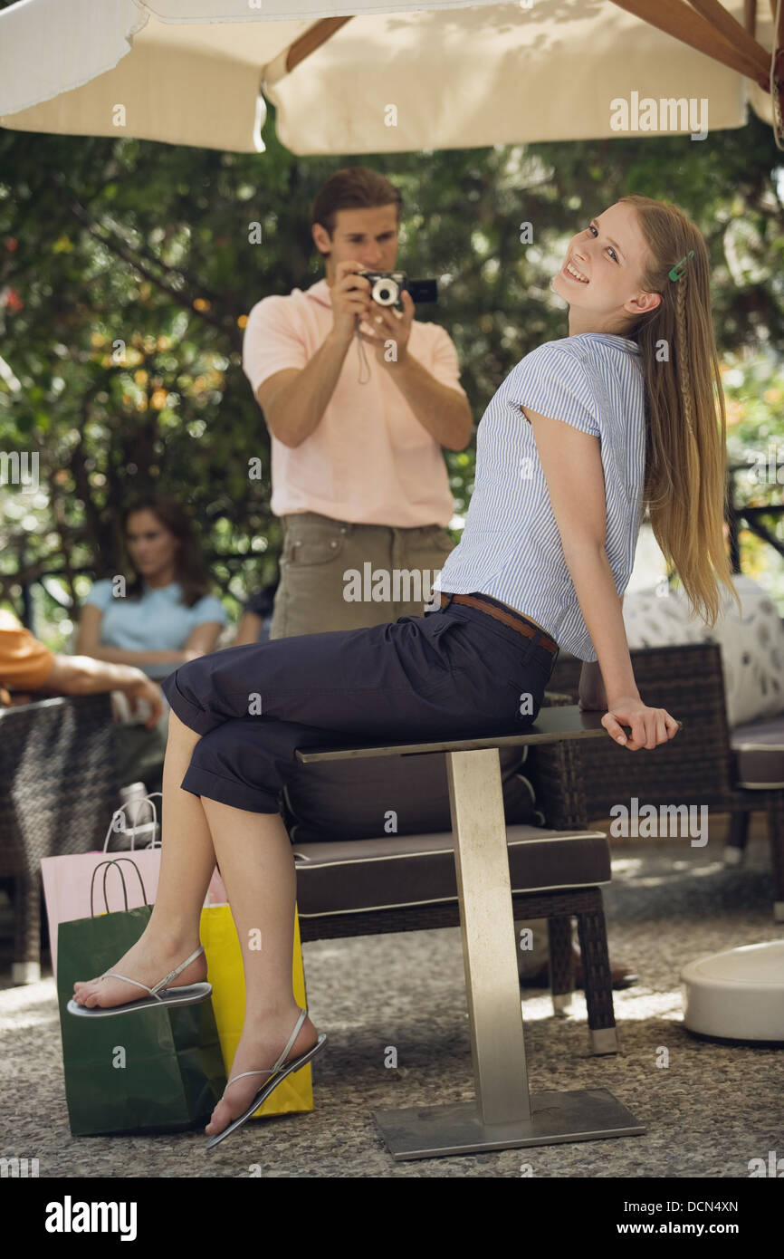 Woman posing with shopping bags for man photographing her Stock Photo
